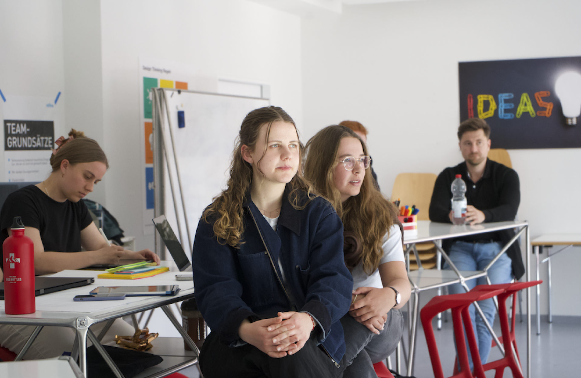 Studierende sitzen an Tischen