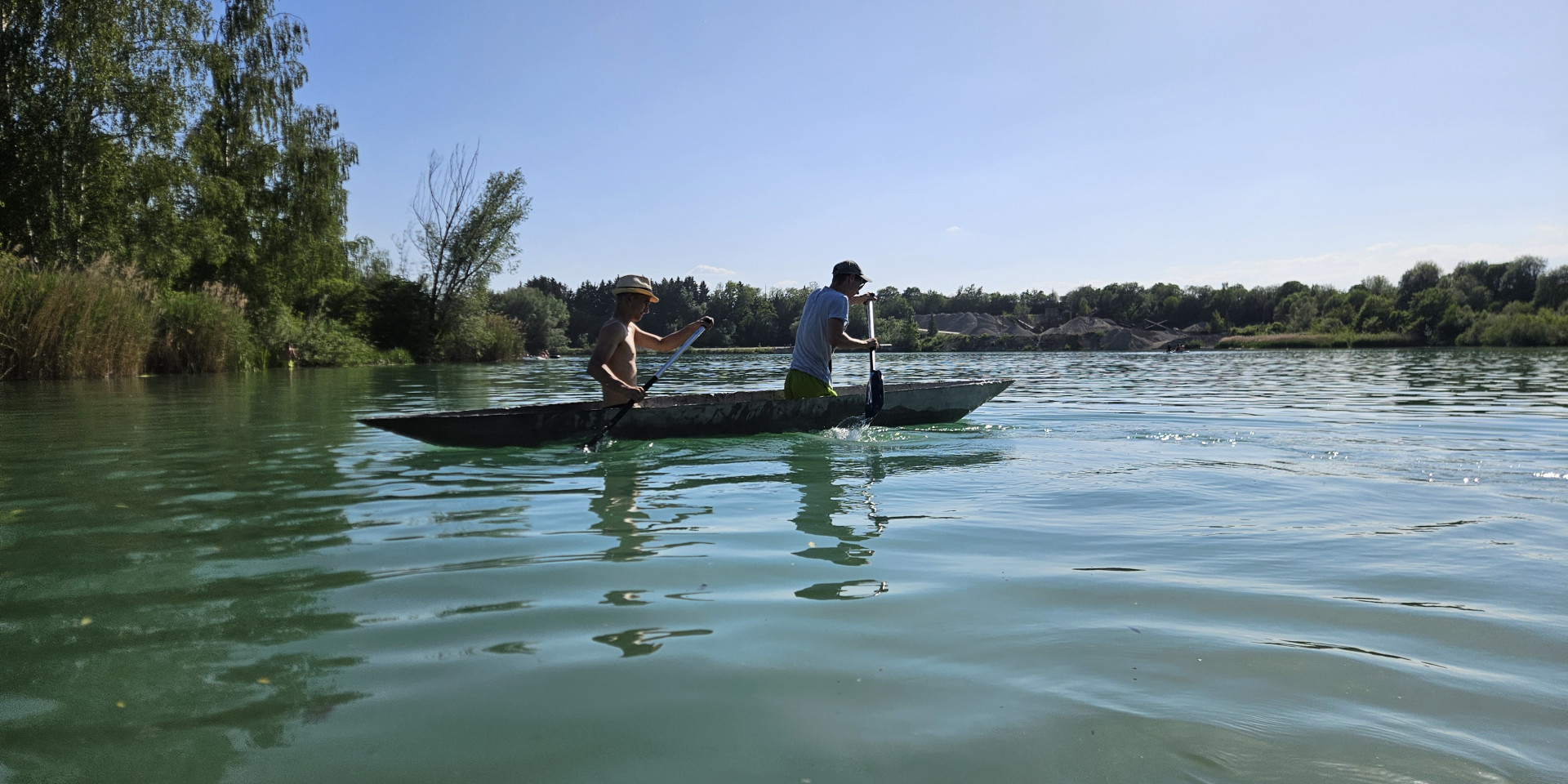 Zwei Männer in einem Betonkanu auf dem See