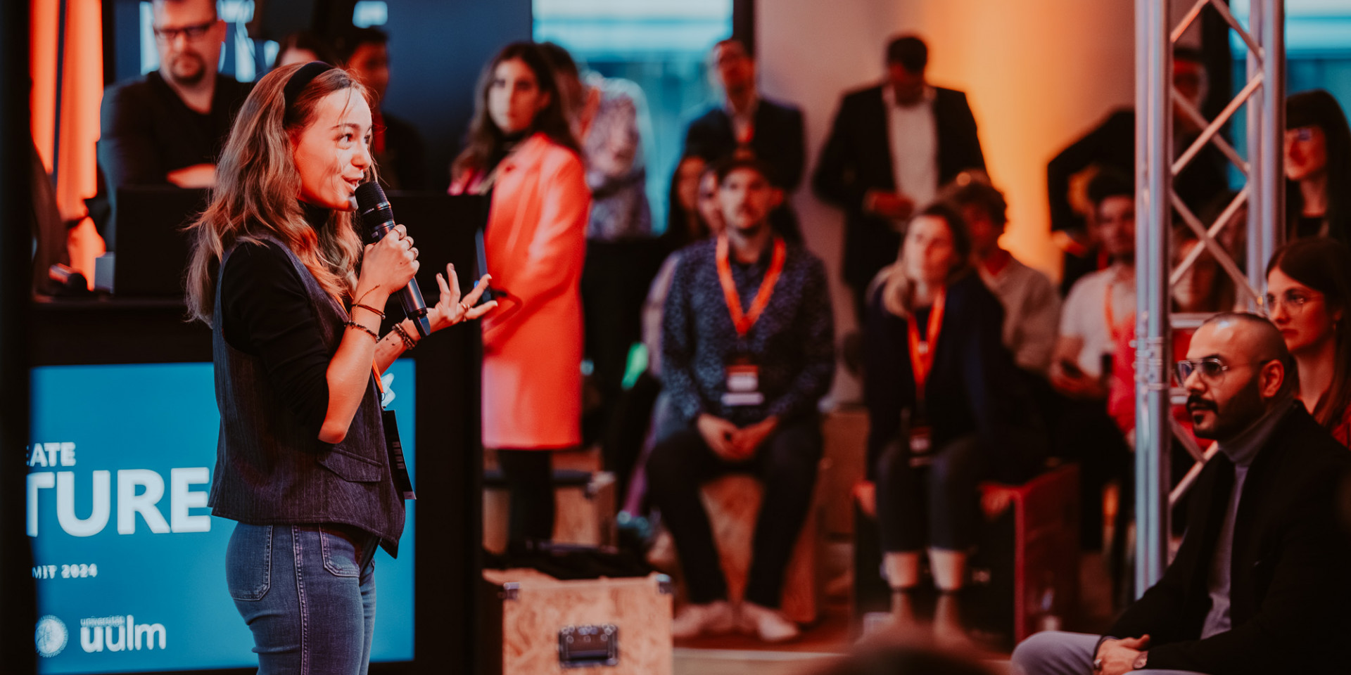 Eine Frau steht auf einer Bühne und präsentiert