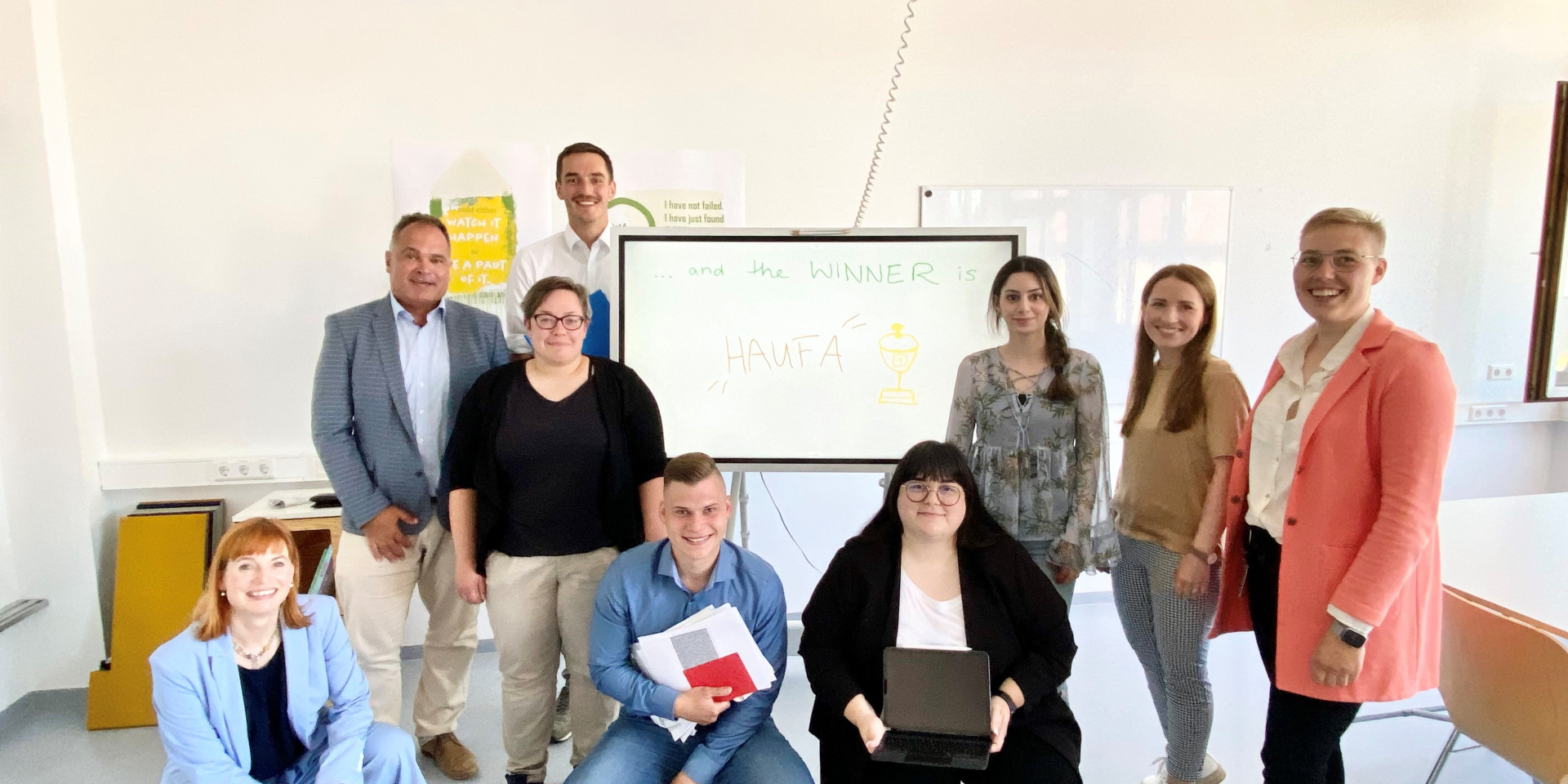 Neun Menschen verteilt vor einem Whiteboard