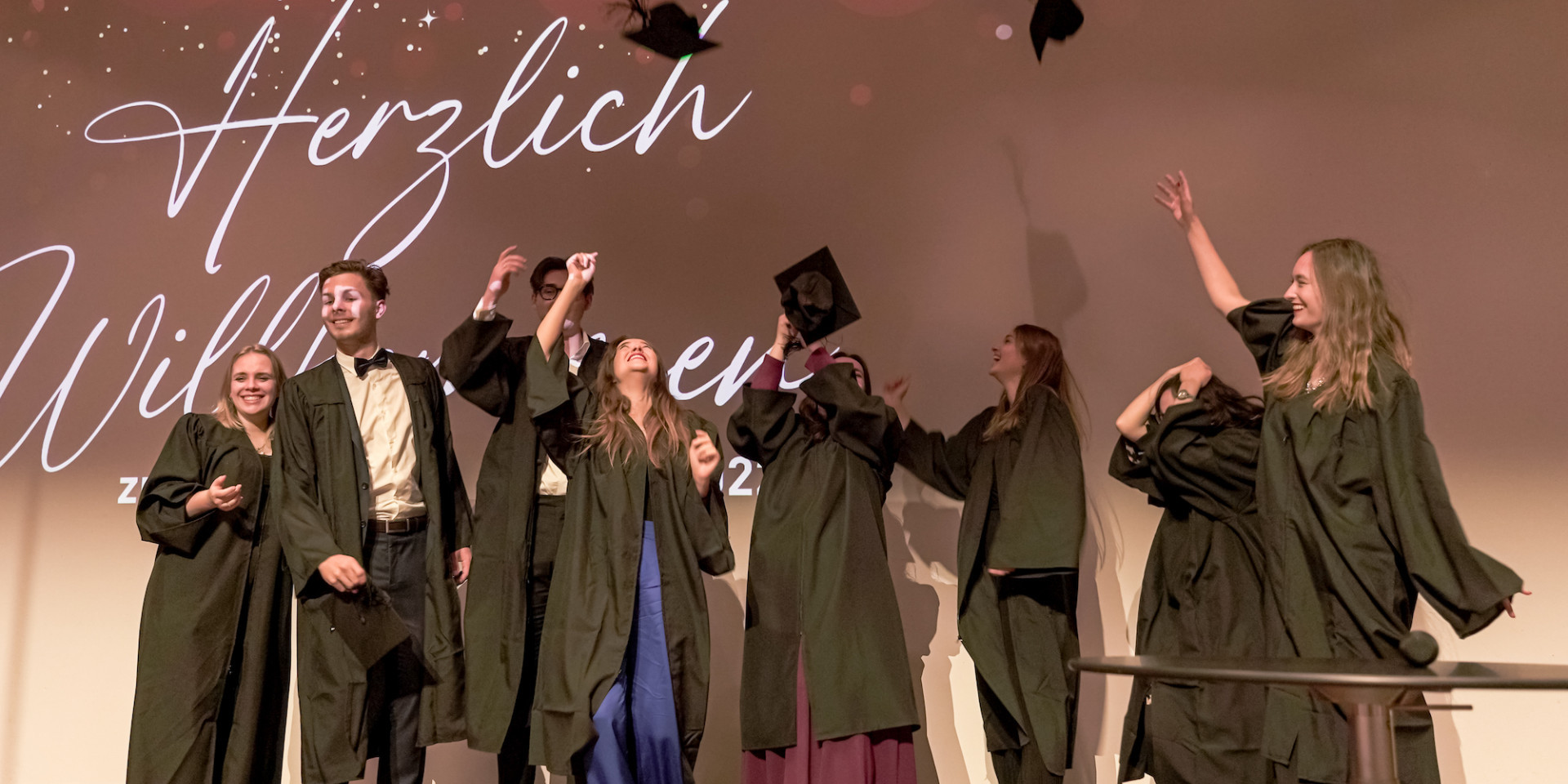 Absolvent*innen werfen Hüte in die Luft