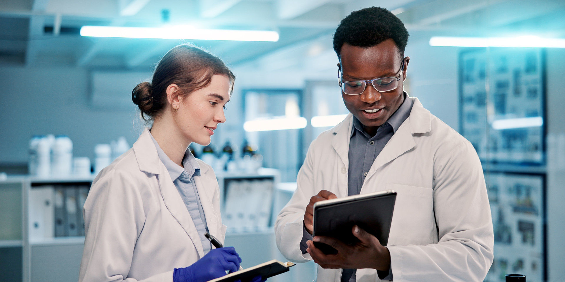 Ein Mann und eine Frau stehen im Labor mit Tablets in der Hand