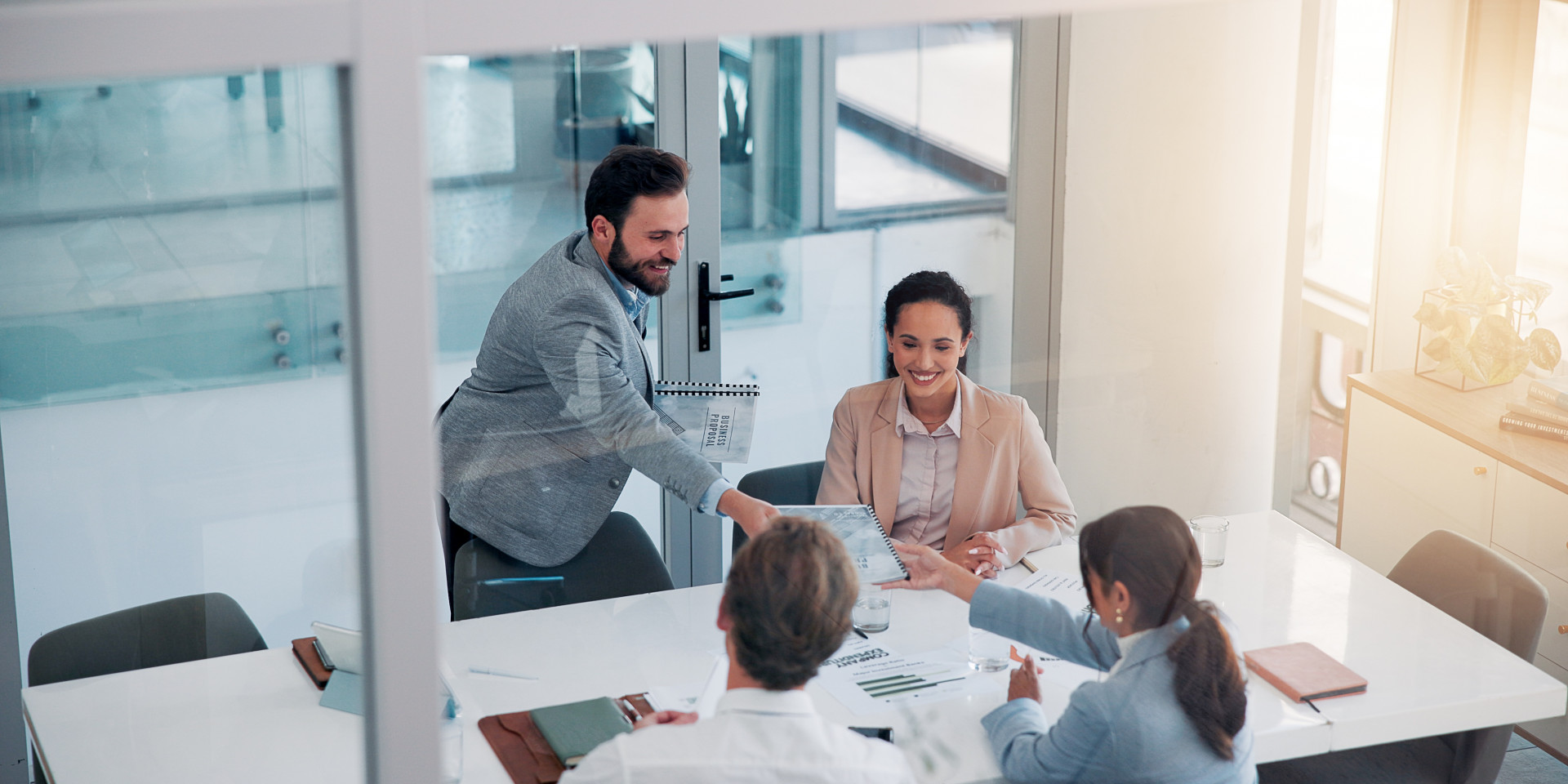 Vier Personen sitzen an einem Tisch und arbeiten