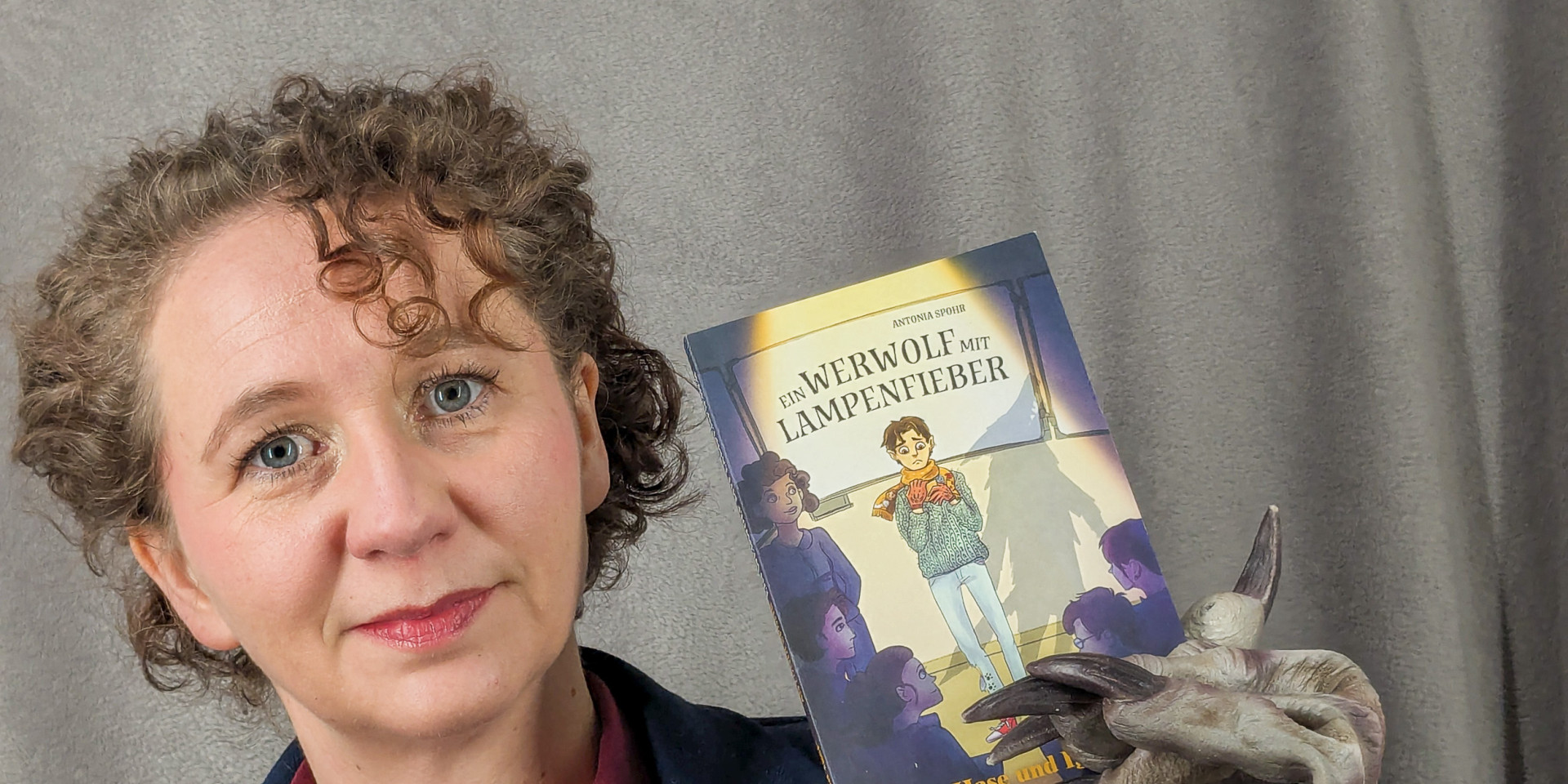 Frau hält Buch in die Kamera 