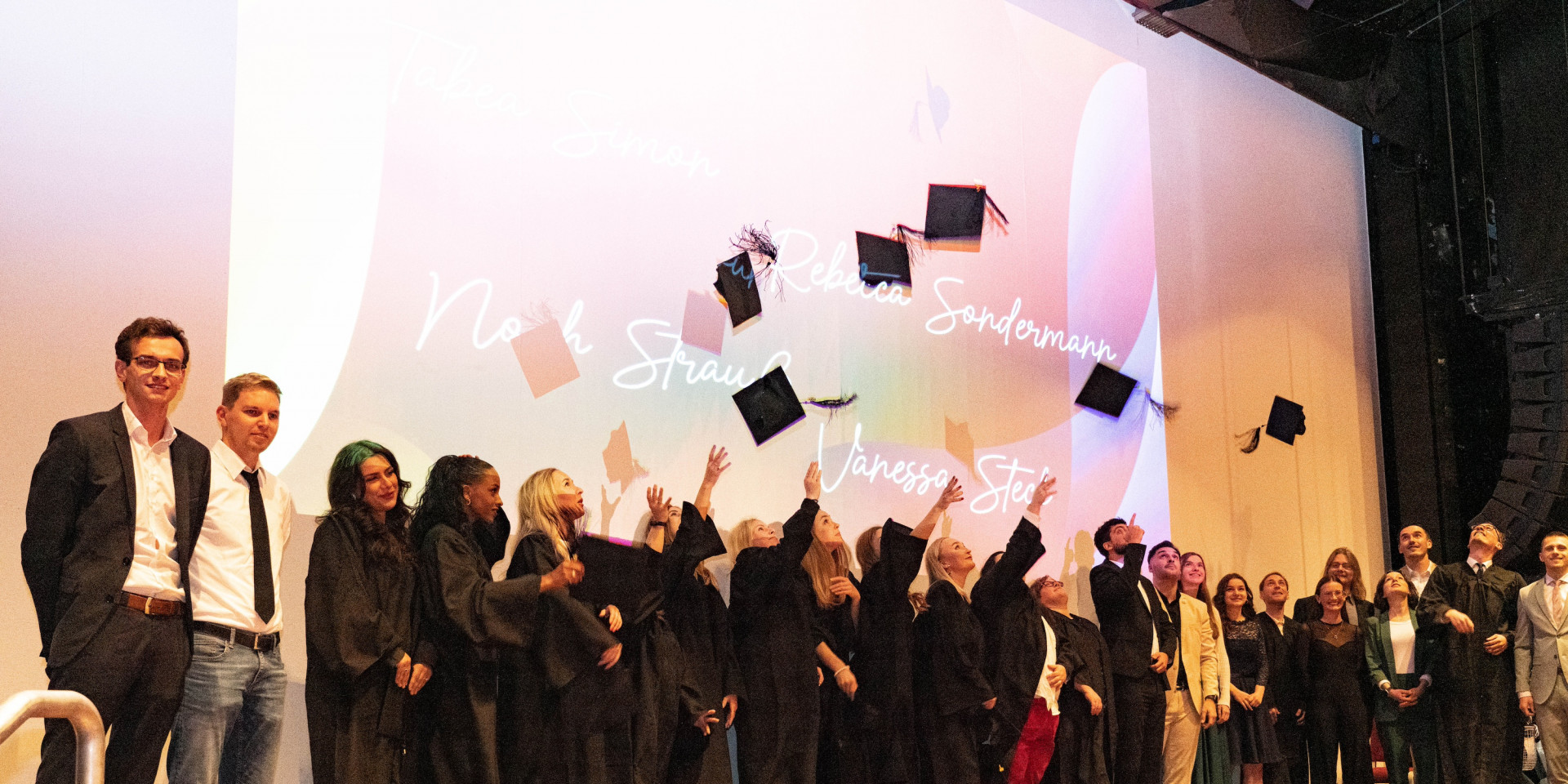 Studierende werfen Absolventenhüte in die Luft