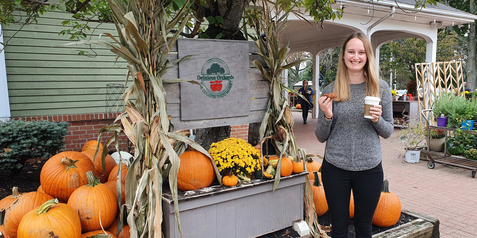 Junge Frau vor einem Kürbisstand in Amerika