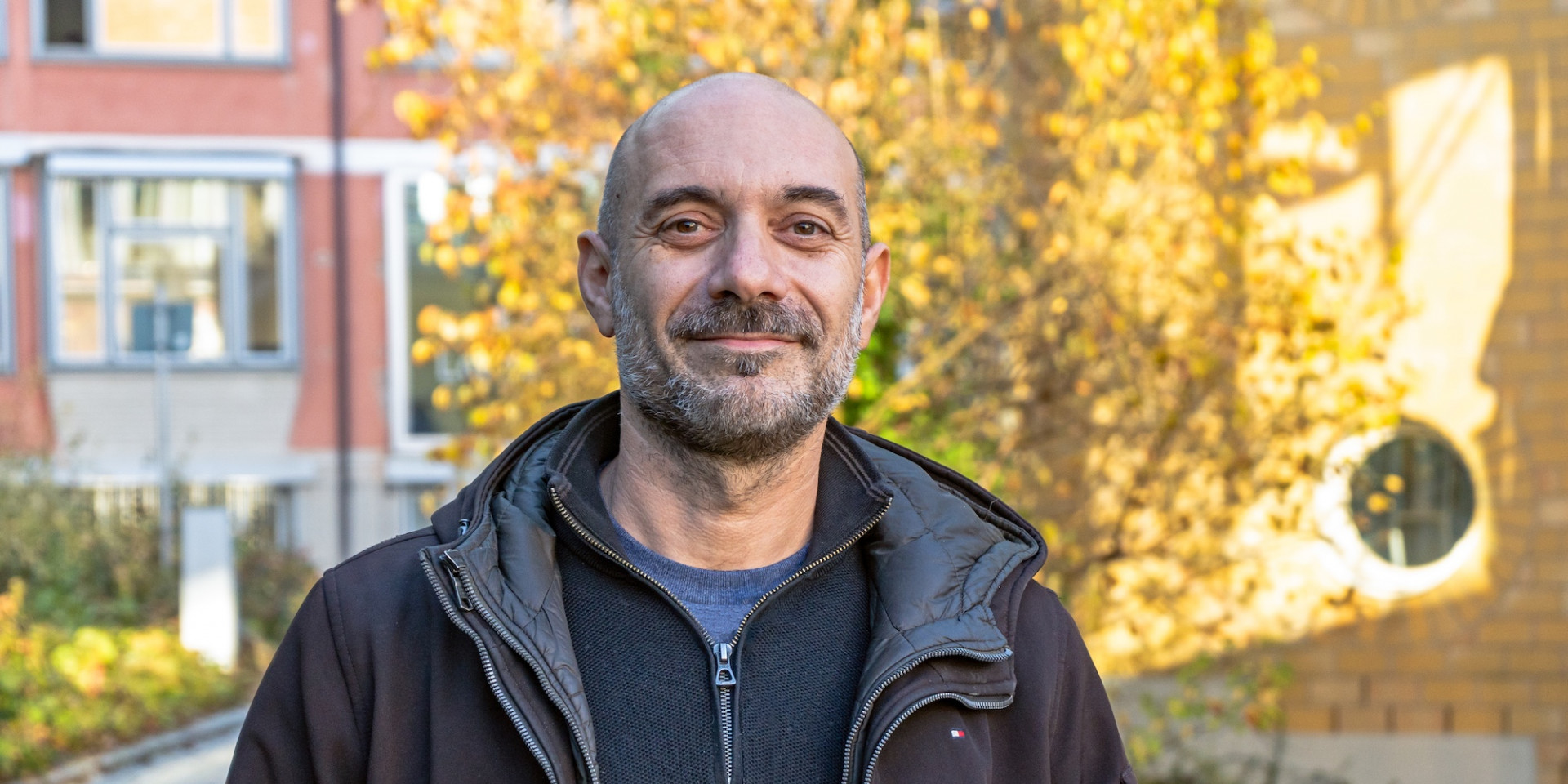 Mann im Porträt draußen vor herbstlichem Baum