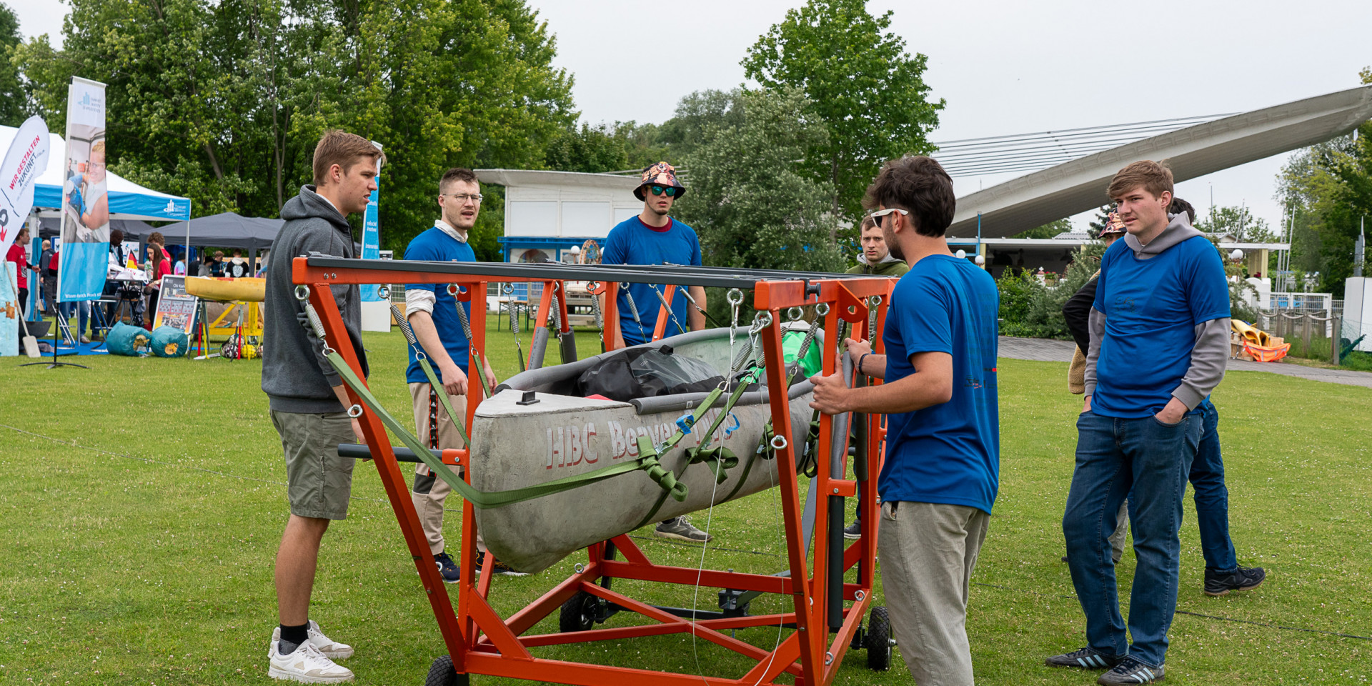 Männer stehen um ein Betonkanu herum
