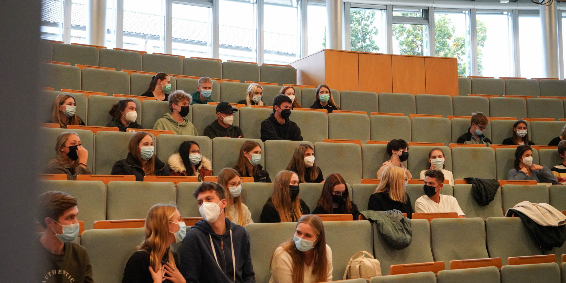 Studierende in großem Hörsaal mit Masken