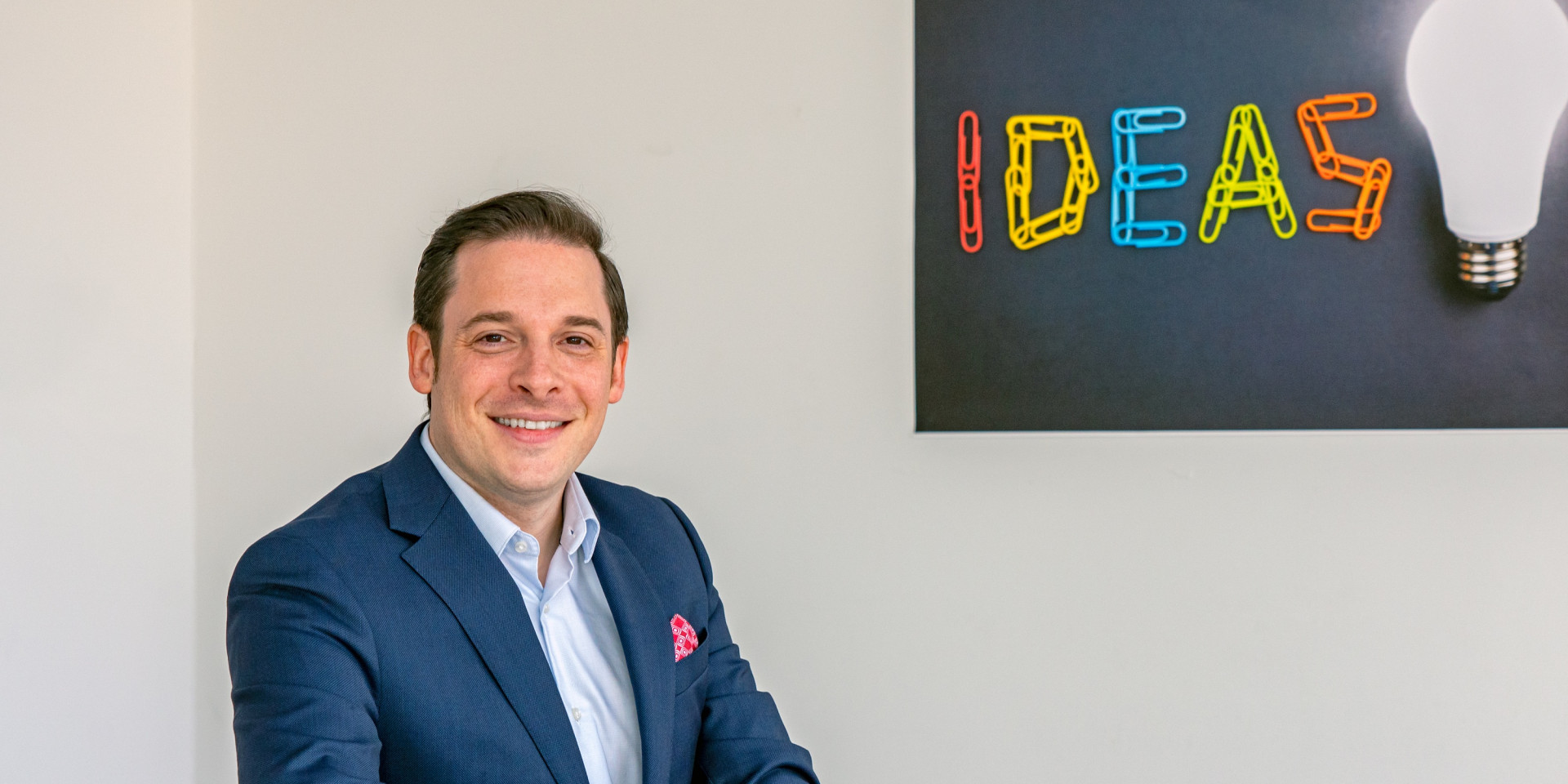 Mann im Anzug sitzt an einem weißen Tisch