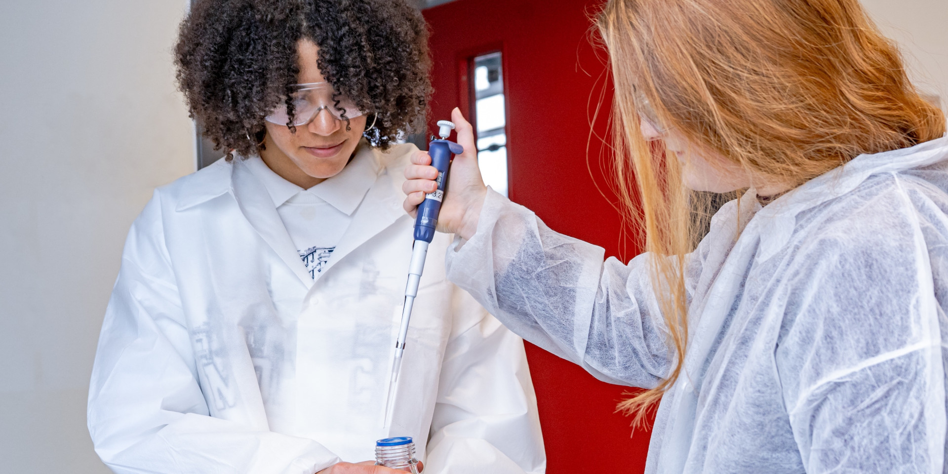 Zwei Schüler*innen führen einen Versuch durch im Labor