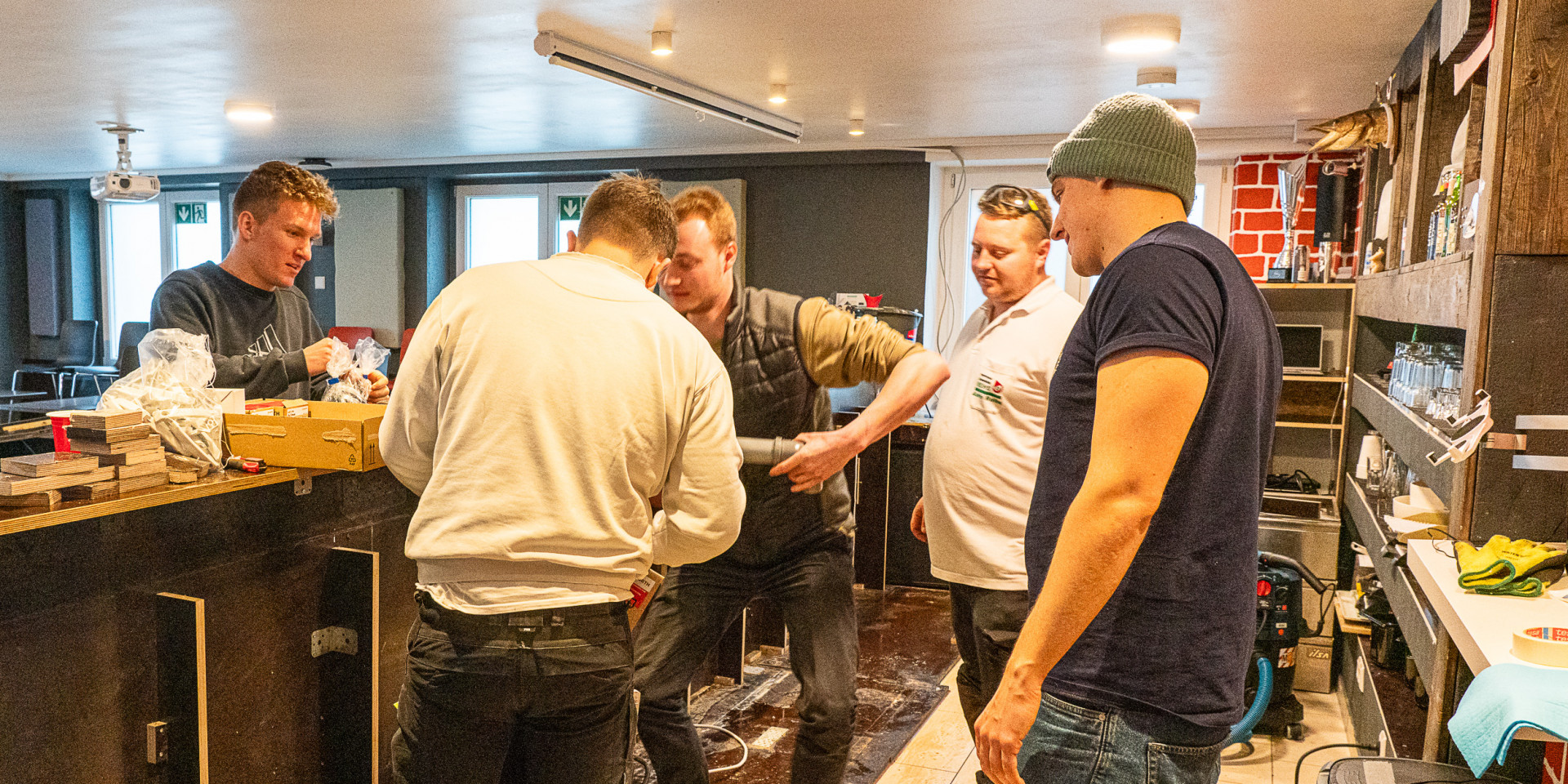 Fünf Männer in einer Kneipe, die die Theke ausbauen