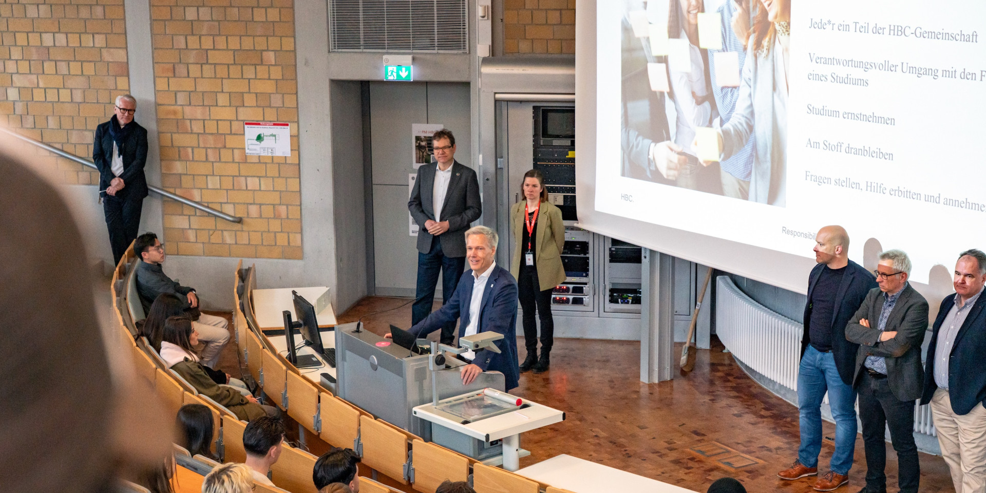 Prof. Bahr steht im Hörsaal und begrüßt Studierende