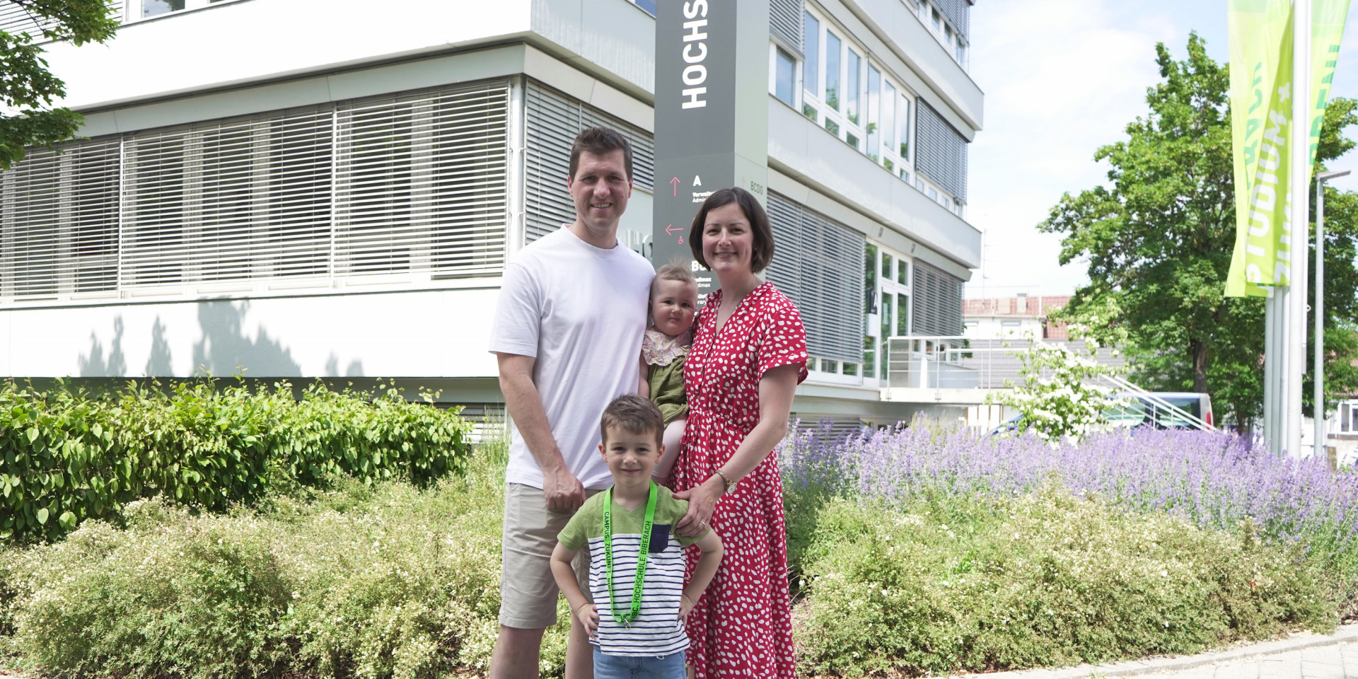 Mann, Frau und zwei Kinder vor Gebäude