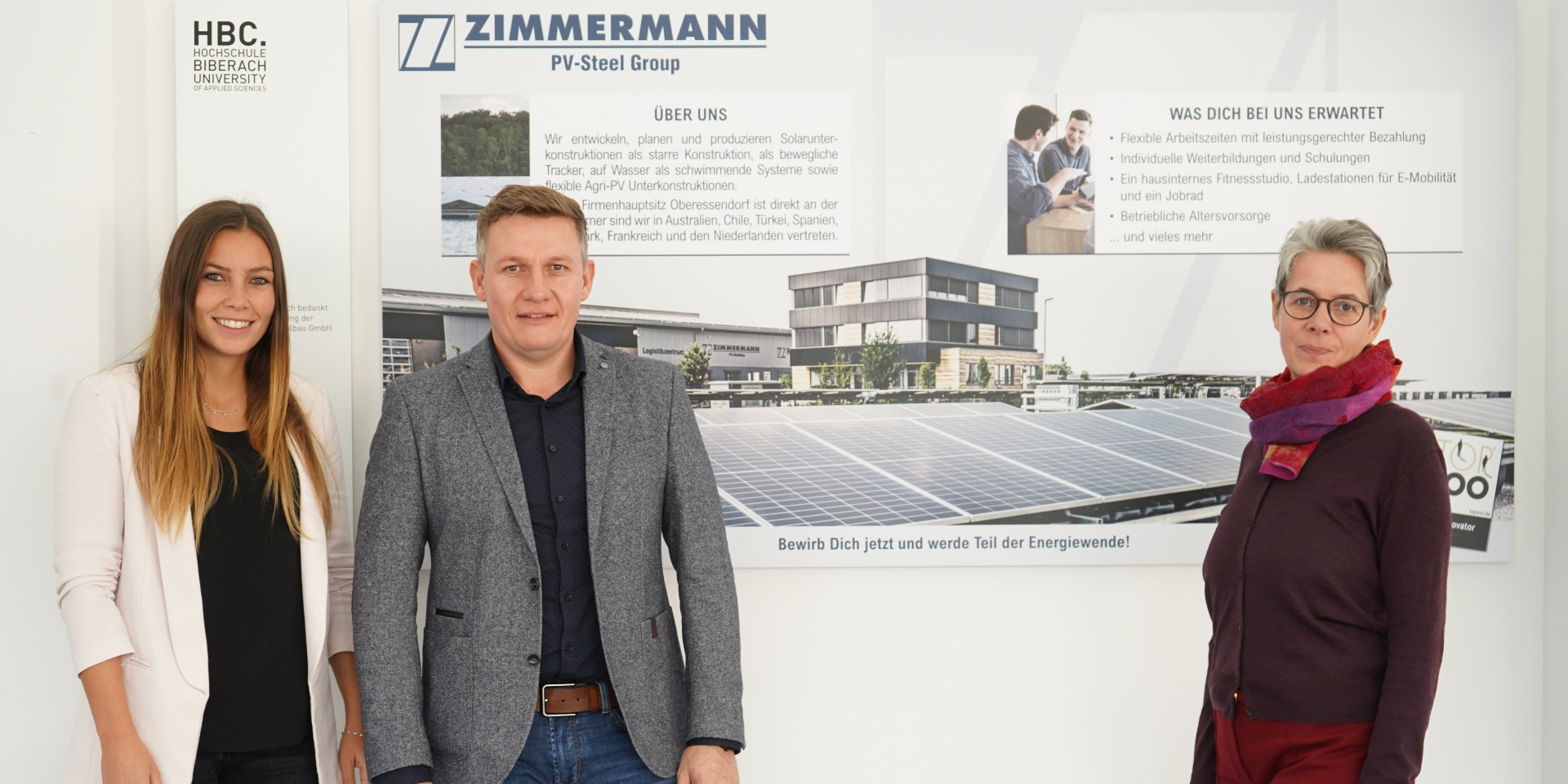 Drei Personen vor Logo PV Stahlbau