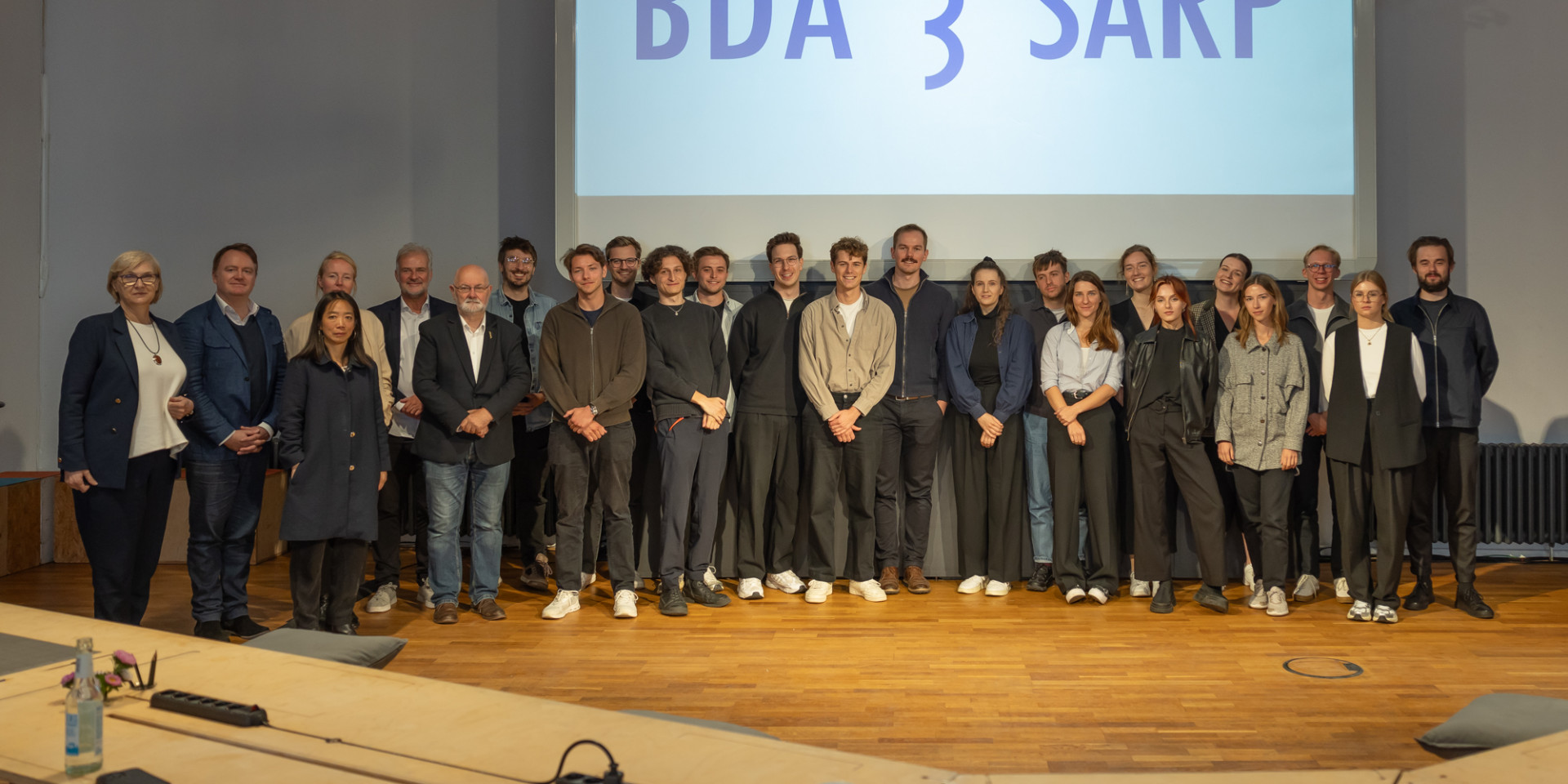 Viele Personen stehen bei einer Ehrung auf der Bühne