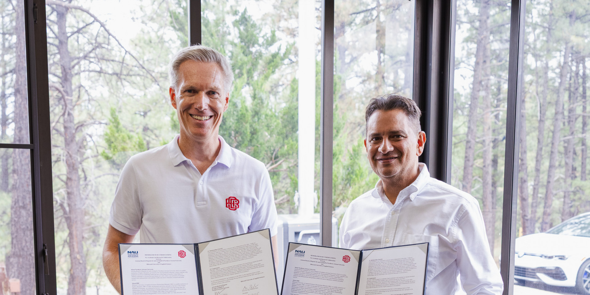 Zwei Männer präsentieren unterschriebene Verträge