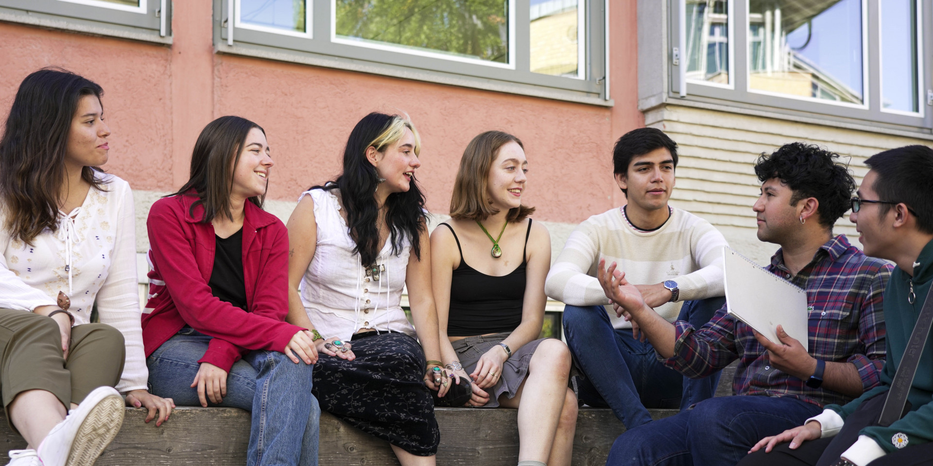 Studierende aus verschiedenen Nationen sitzen draußen