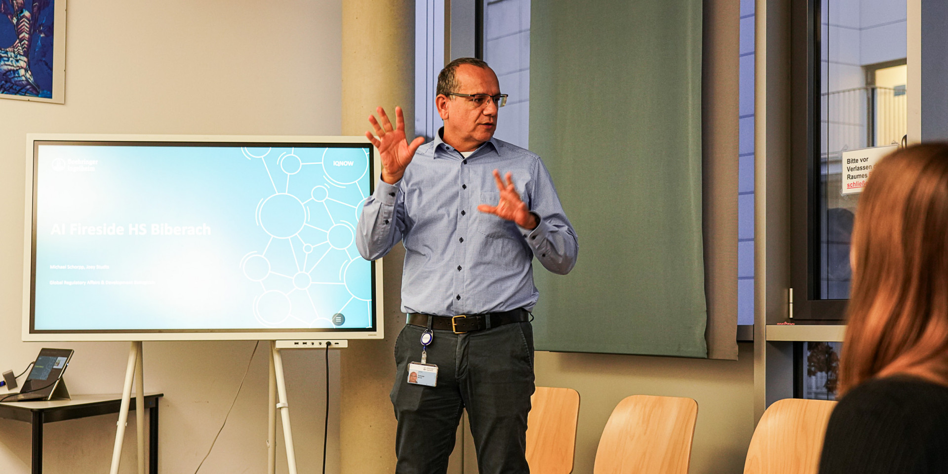 Mann steht vor einem Bildschirm und präsentiert