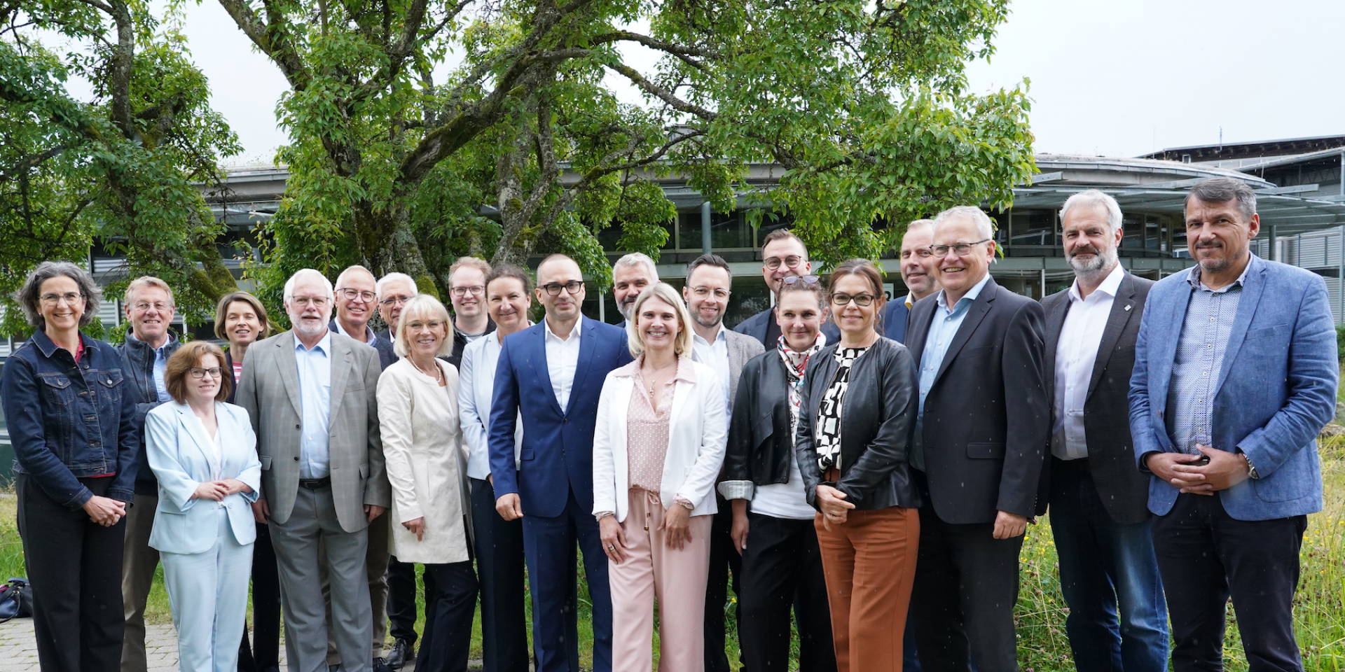 Viele Personen stehen draußen für ein Gruppenfoto