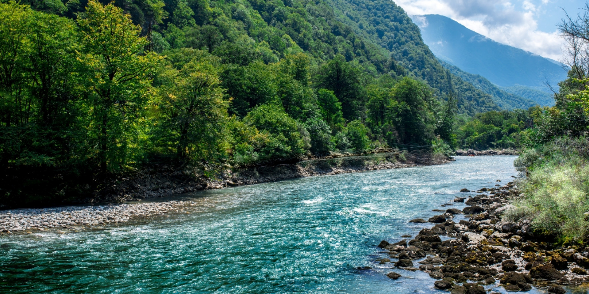 Ein klarer Fluss fließt durch eine Berglandschaft