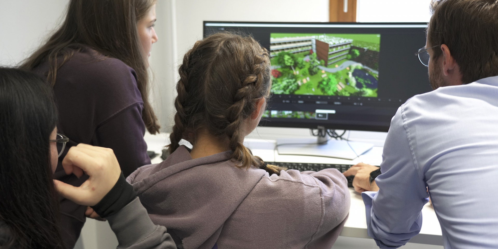 Schüler*innen vor einem PC