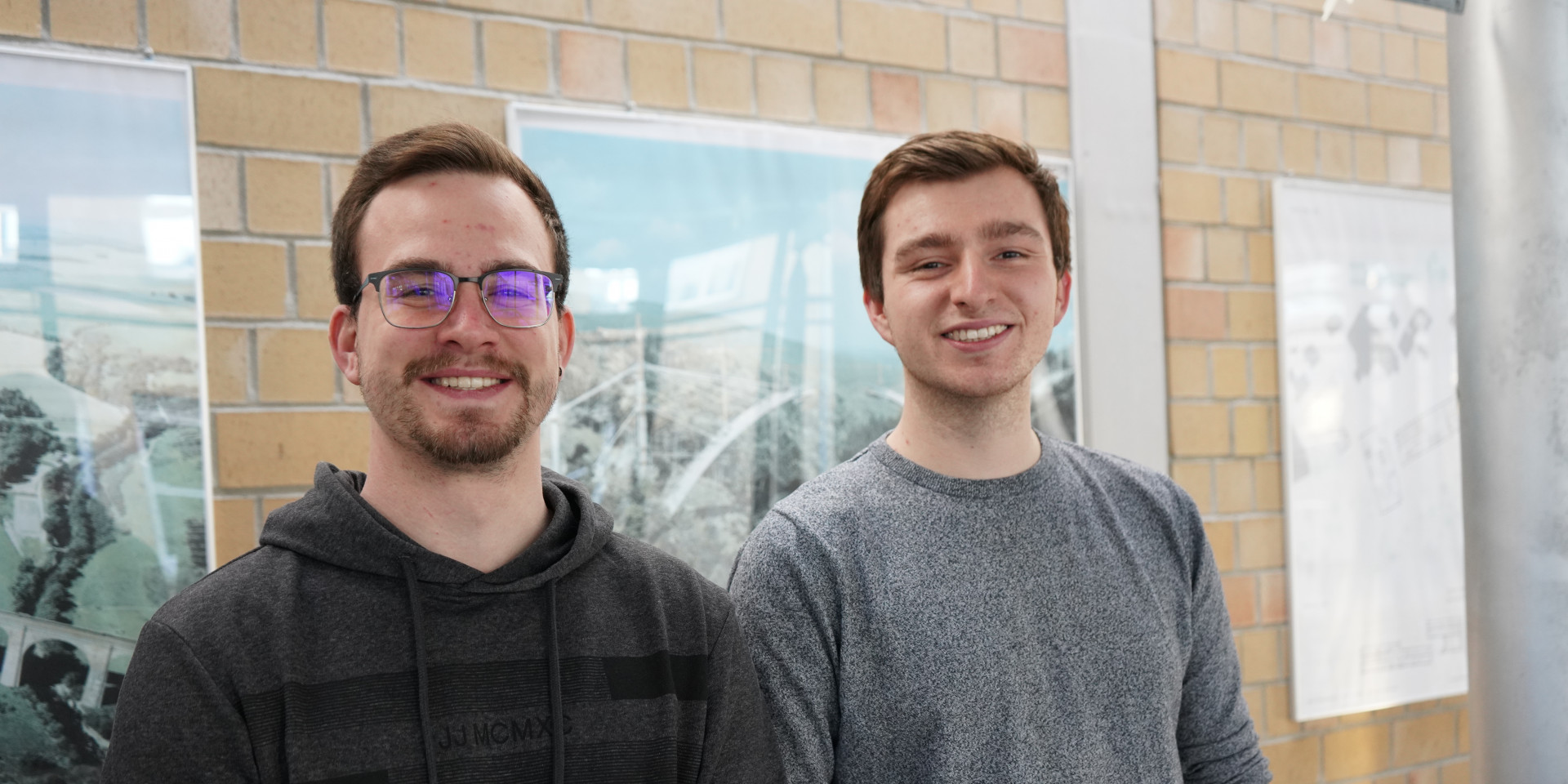 Zwei Studierende stehend vor Wand