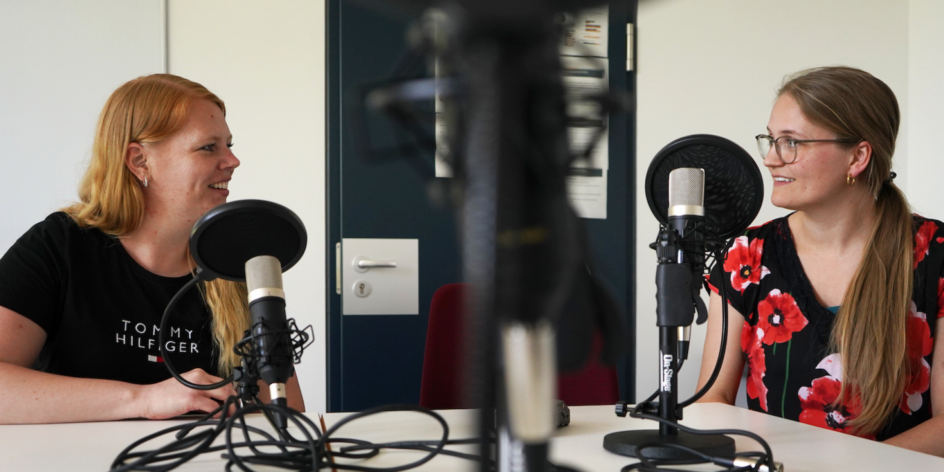 Zwei Frauen sitzen am Mikrofon bei Podcastaufnahme