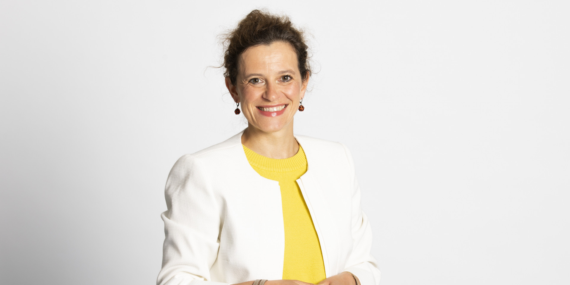 Frau im Porträt mit gelbem Shirt und weißem Blazer