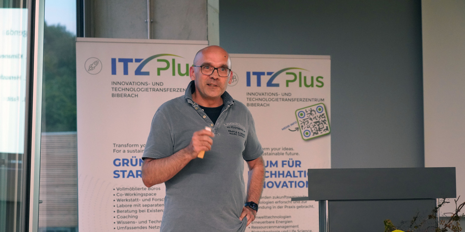 Mann mit Mikrofon hält Vortrag