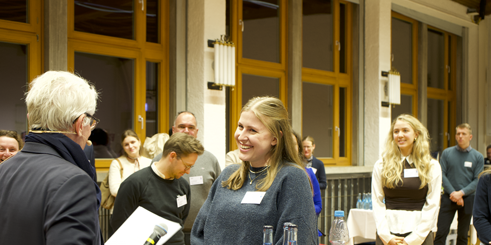 Mann übergibt Urkunde an Studentin