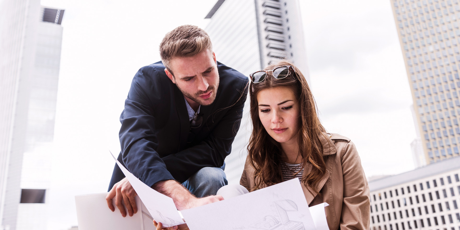 Ein Mann und eine Frau halten einen Bauplan