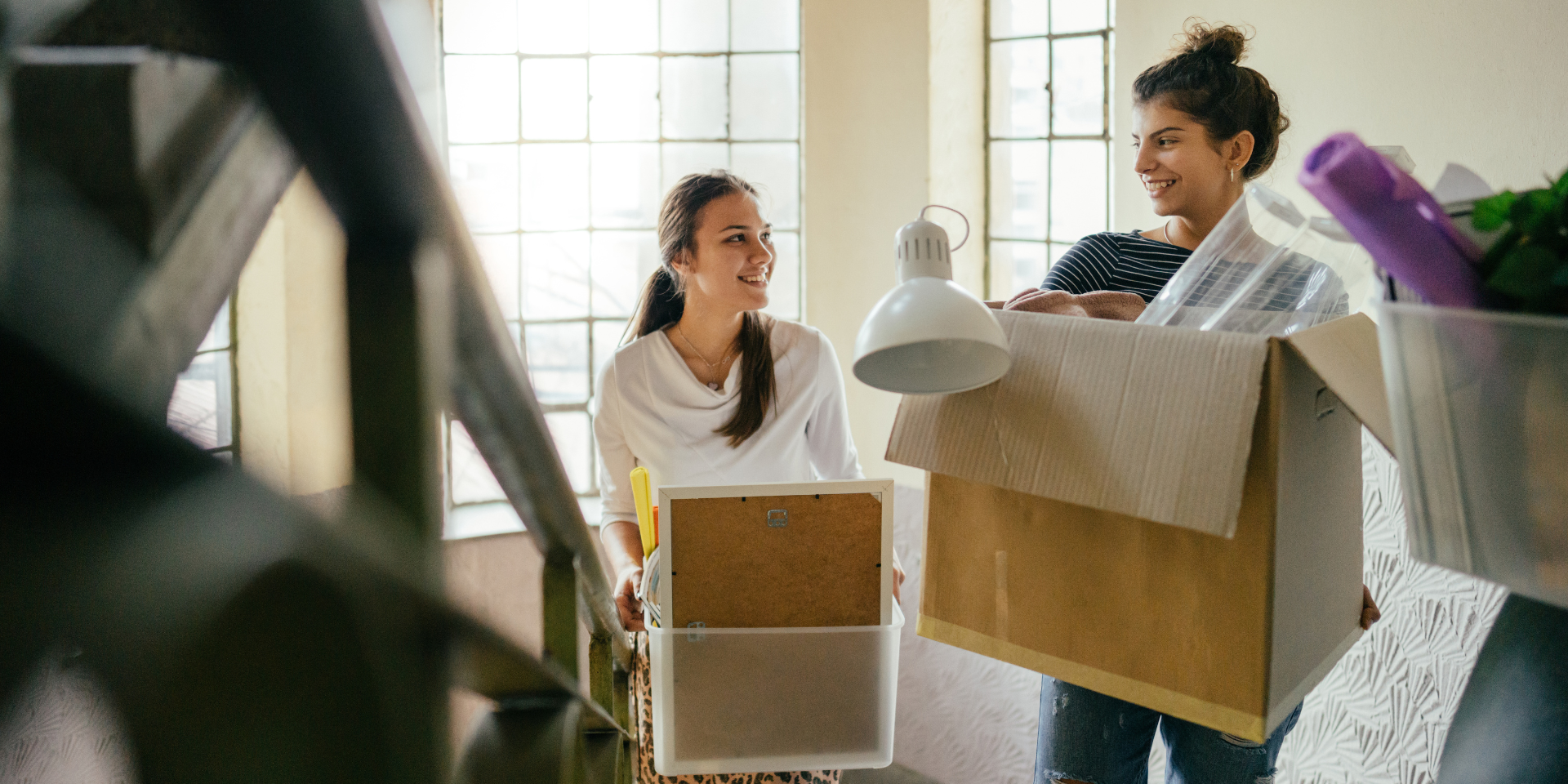 Zwei Frauen tragen Umzugskartons 