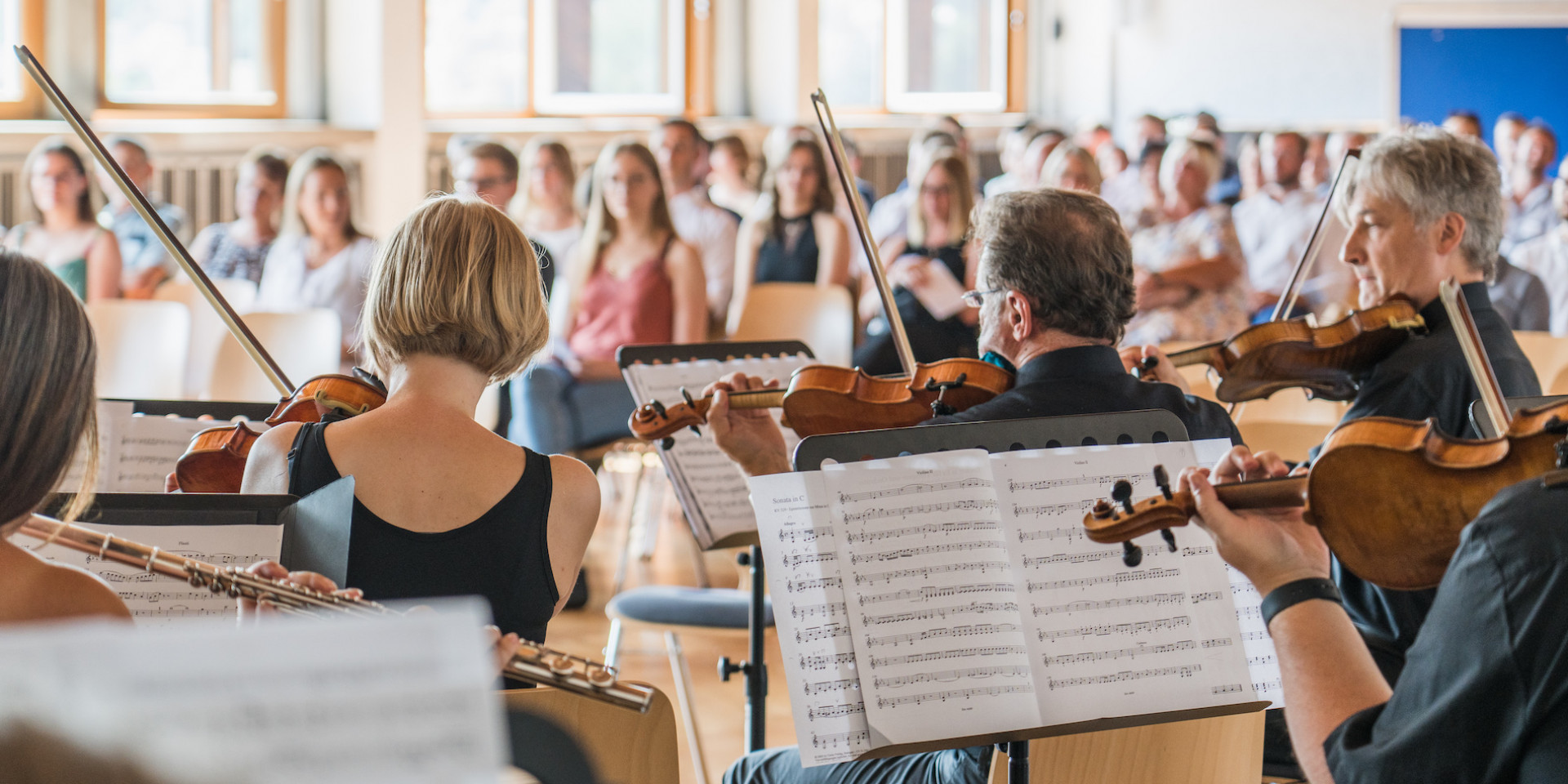 Orchester von hinten mit Einblick in Noten