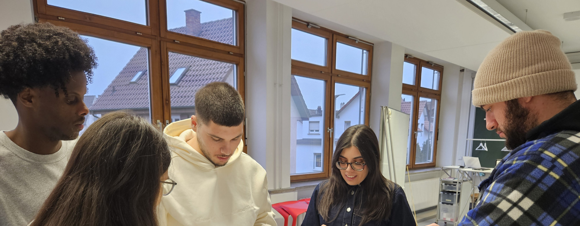 Studierende stehen an einem Tisch und basteln mit Marshmallows