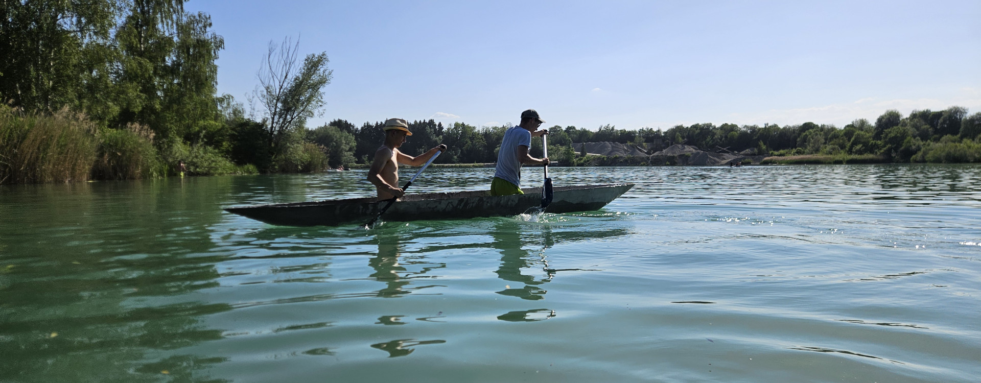 Zwei Männer in einem Betonkanu auf dem See