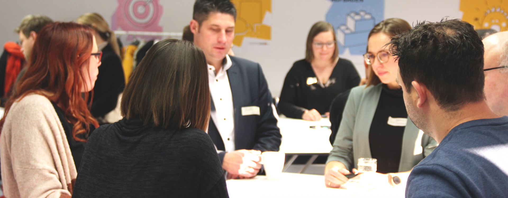 Erwachsene stehen um Tisch herum