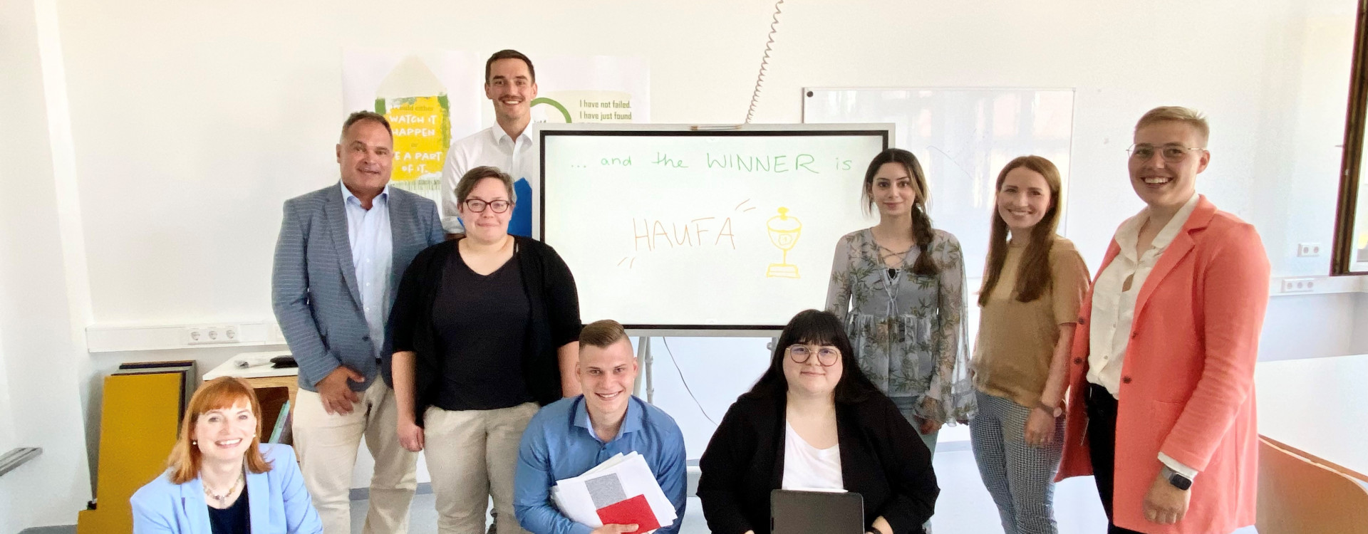 Neun Menschen verteilt vor einem Whiteboard