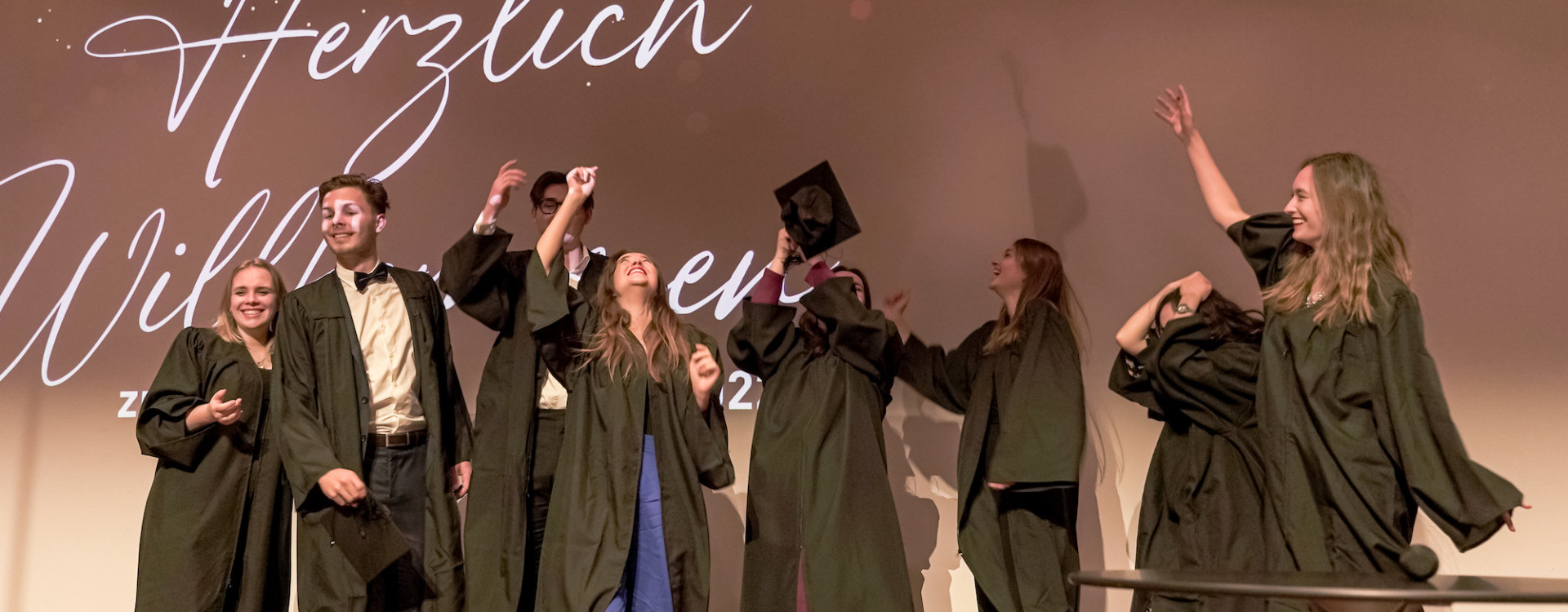 Absolvent*innen werfen Hüte in die Luft