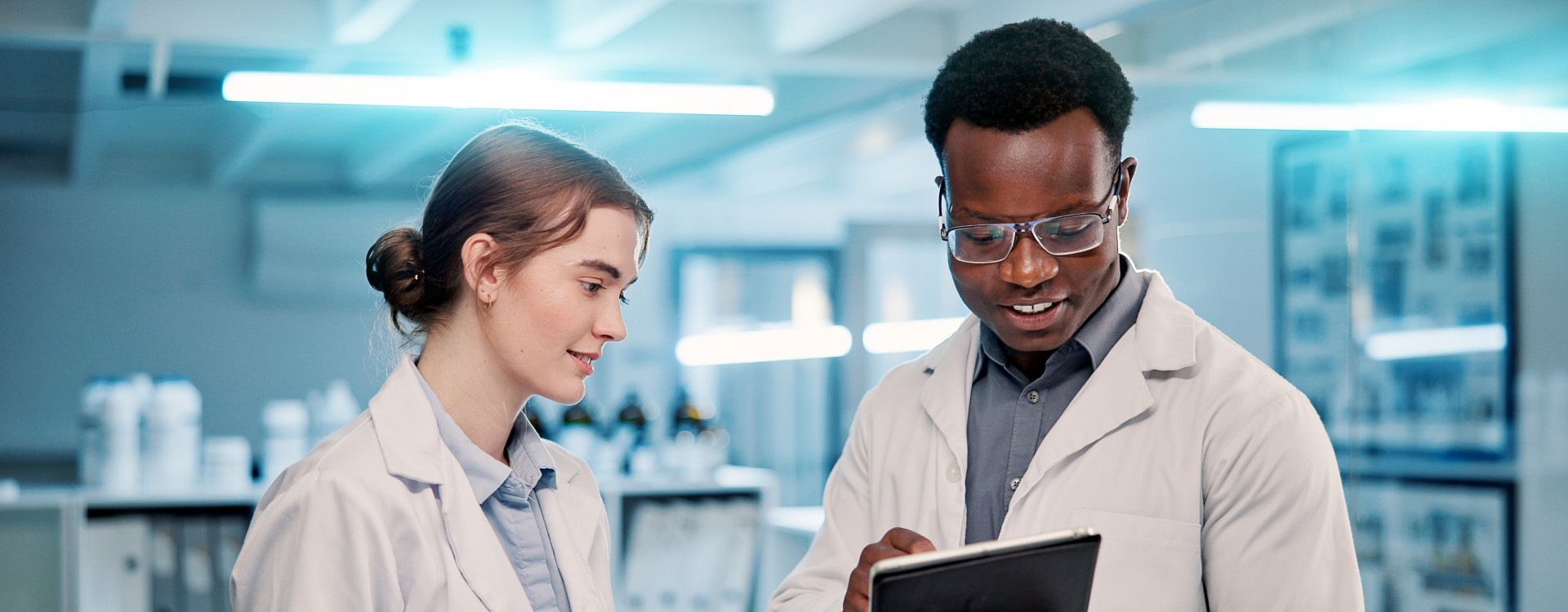 Ein Mann und eine Frau stehen im Labor mit Tablets in der Hand