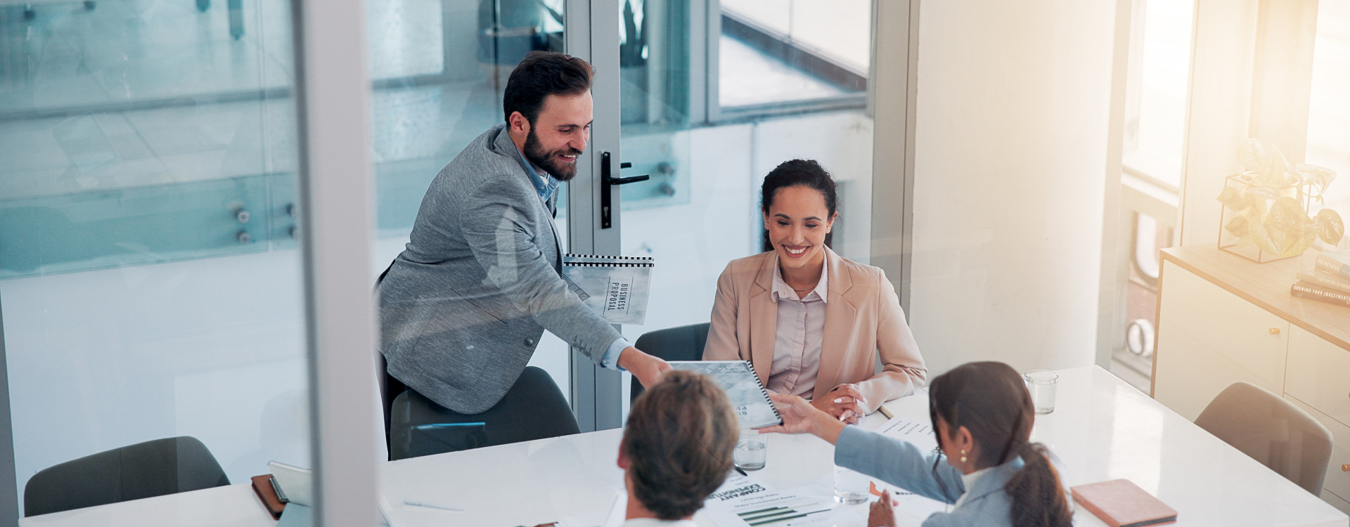 Vier Personen sitzen an einem Tisch und arbeiten