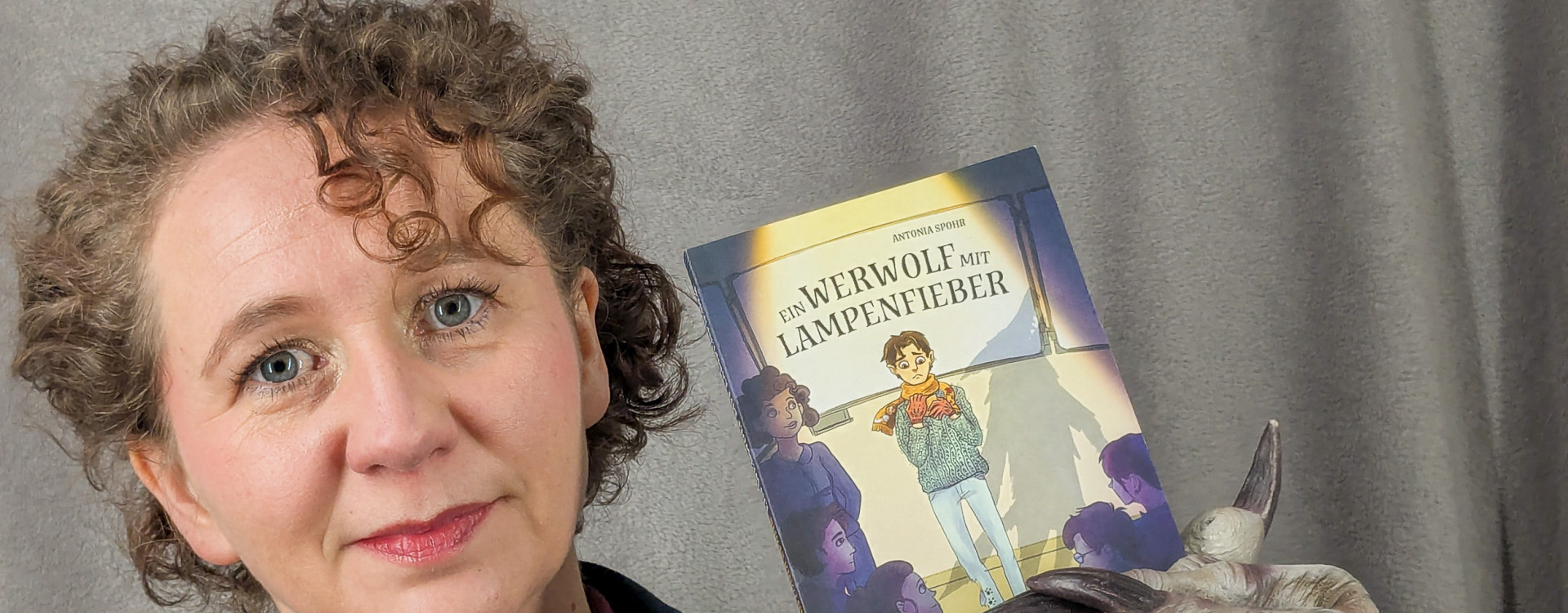 Frau hält Buch in die Kamera