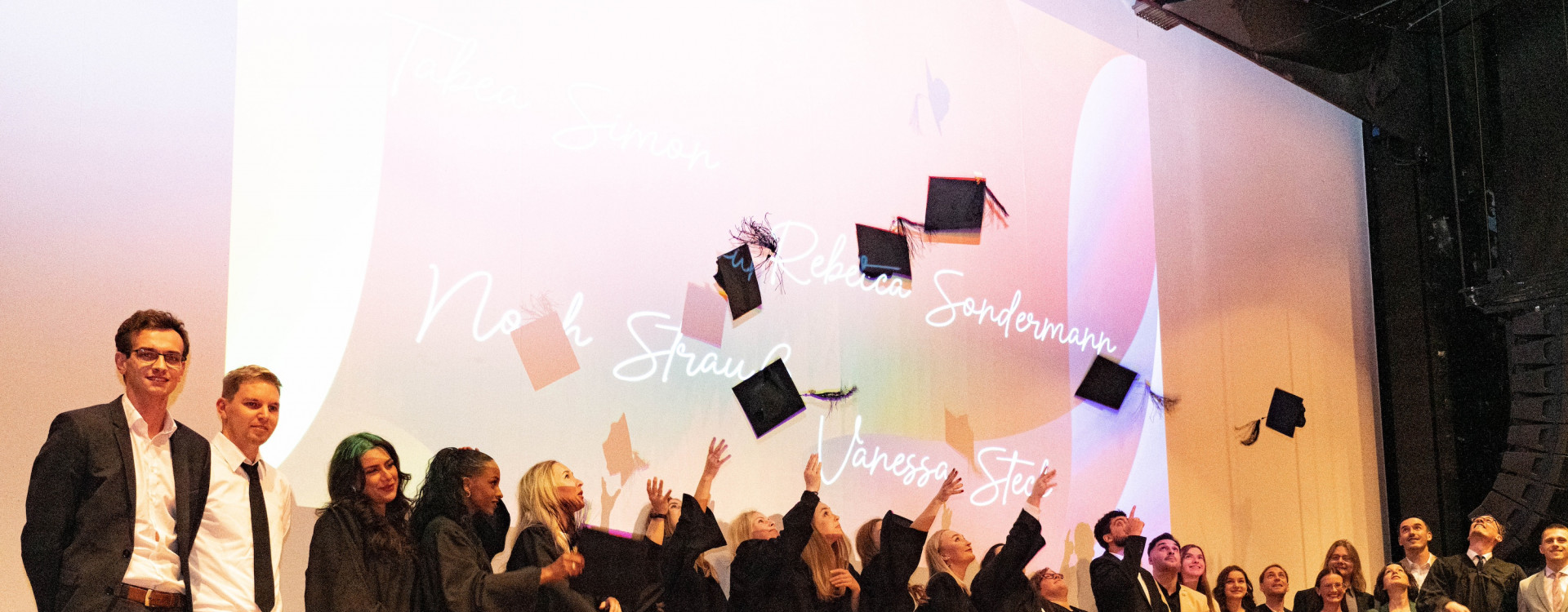 Studierende werfen Absolventenhüte in die Luft