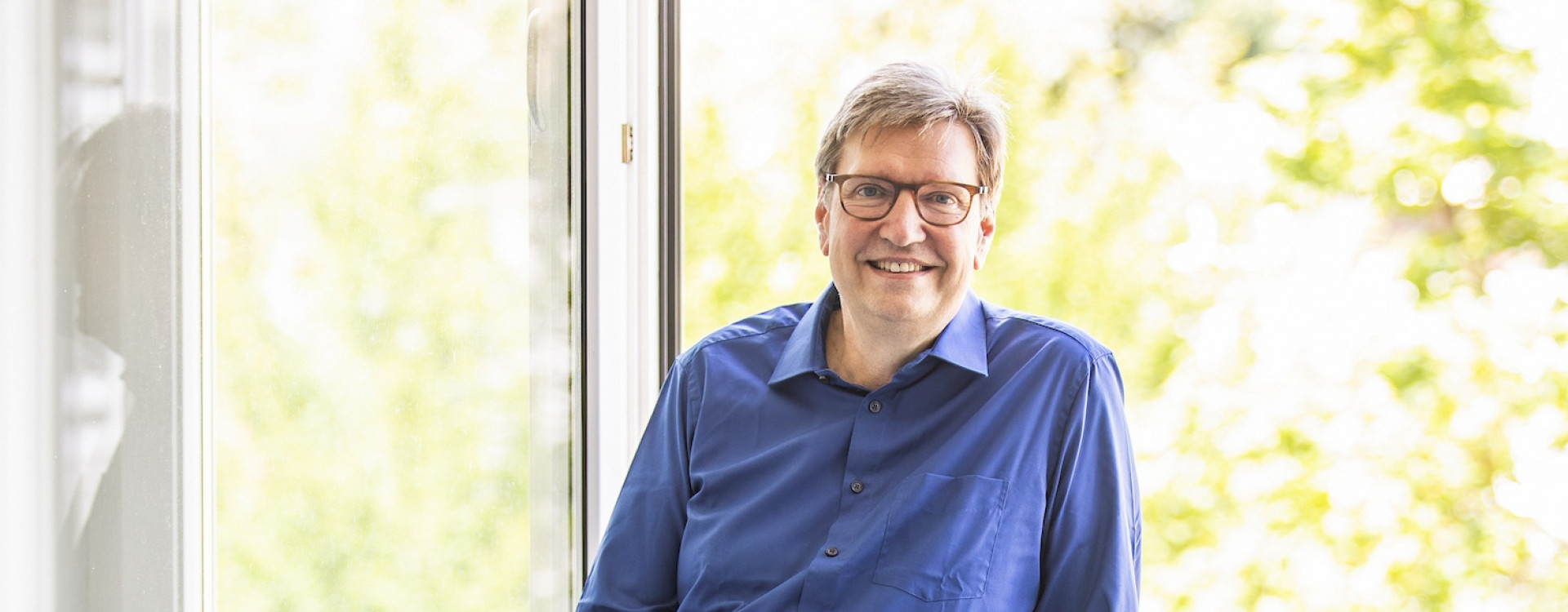 Ein Mann steht in einem Fensterrahmen