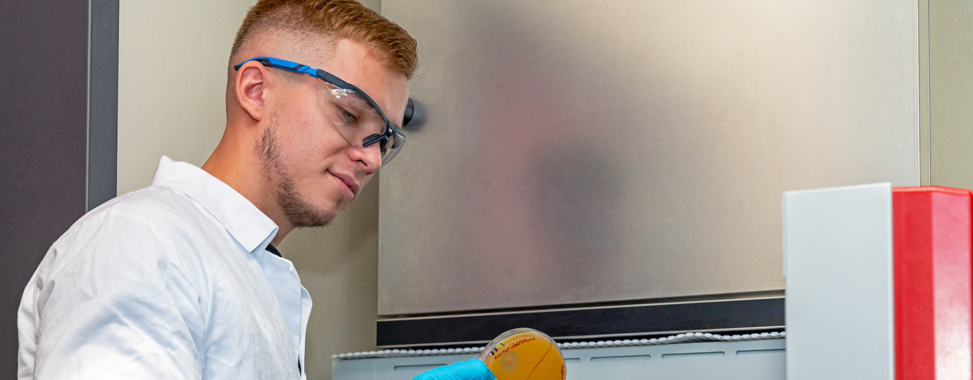 Junger Mann steht im Chemie-Labor