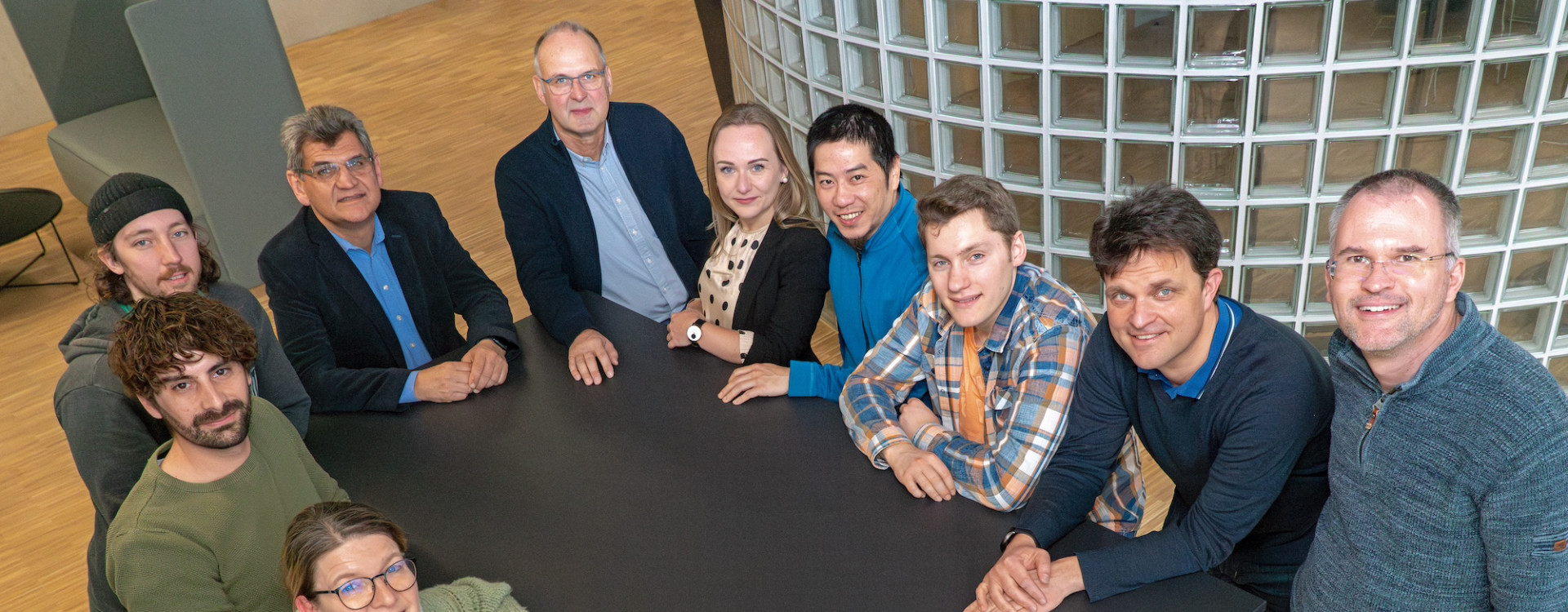 Gruppenbild mit 10 Personen rund um einen Tisch