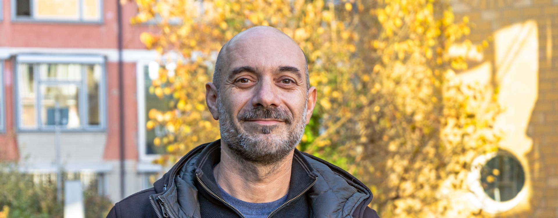 Mann im Porträt draußen vor herbstlichem Baum