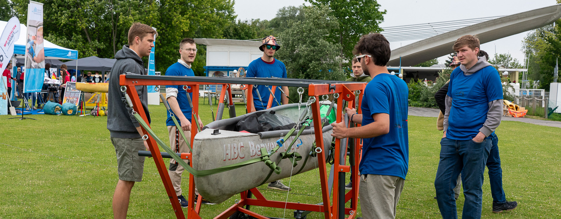 Männer stehen um ein Betonkanu herum