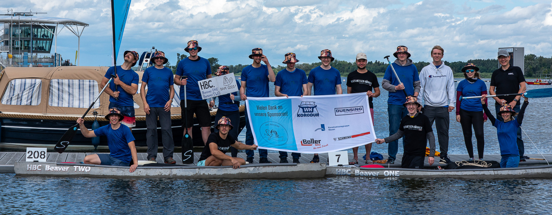Viele Personen stehen auf einem Steg am Wasser