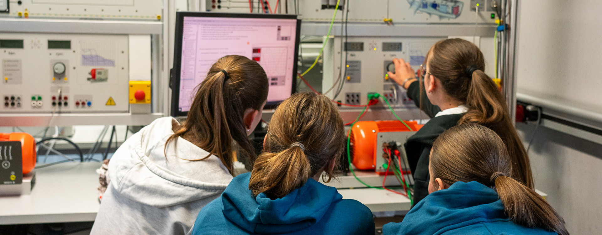 Schülerinnen sitzen vor einem Computer